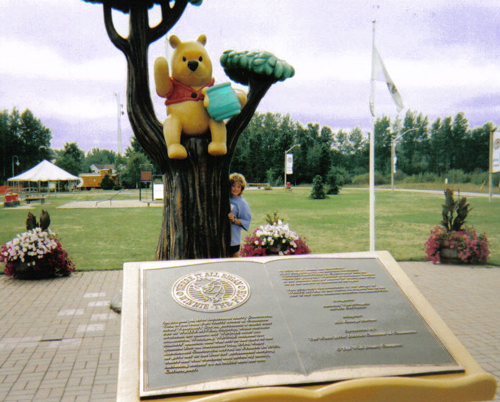 Deb Hoffmann with the Pooh statue in Pooh Park in White River Ontario Canada.